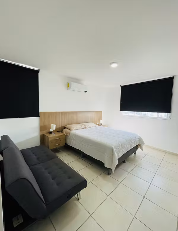 Recámara amoblada con cama y sofá